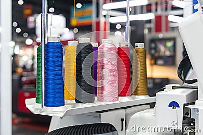 Many colorful cotton reel thread set up at modern and automatic high technology sewing or embroidery machine for textile â€“ Stock Photo